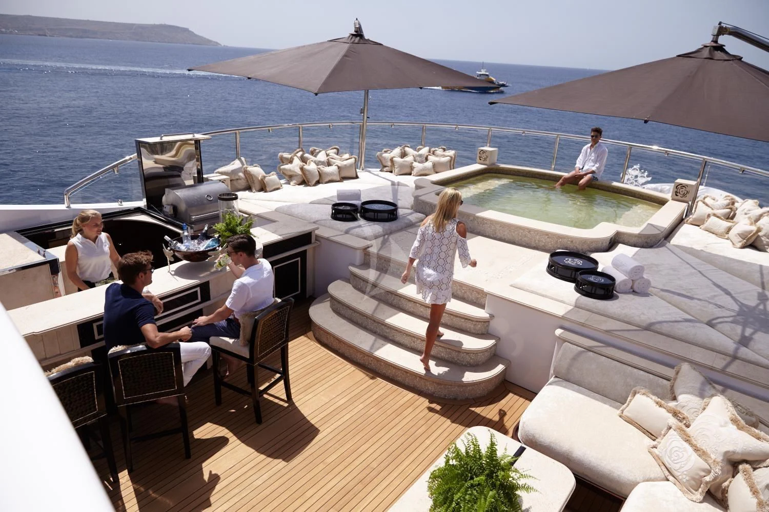 a group of people sitting around a table on a boat aboard ILLUSION V Yacht for Charter