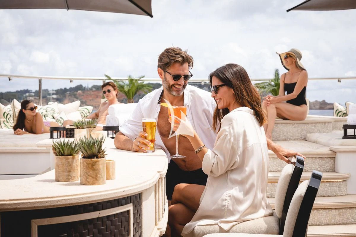 a group of people sitting at a table with drinks on it aboard ILLUSION V Yacht for Charter