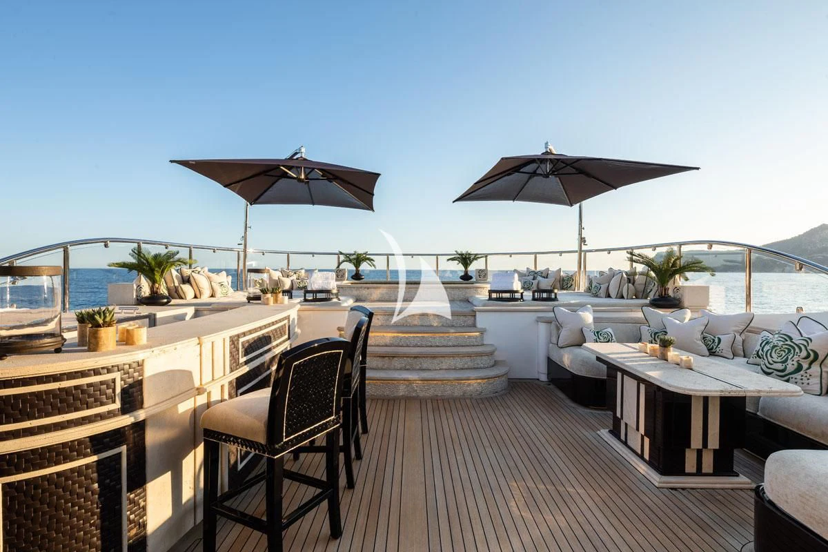 a patio with a deck and umbrellas aboard ILLUSION V Yacht for Charter