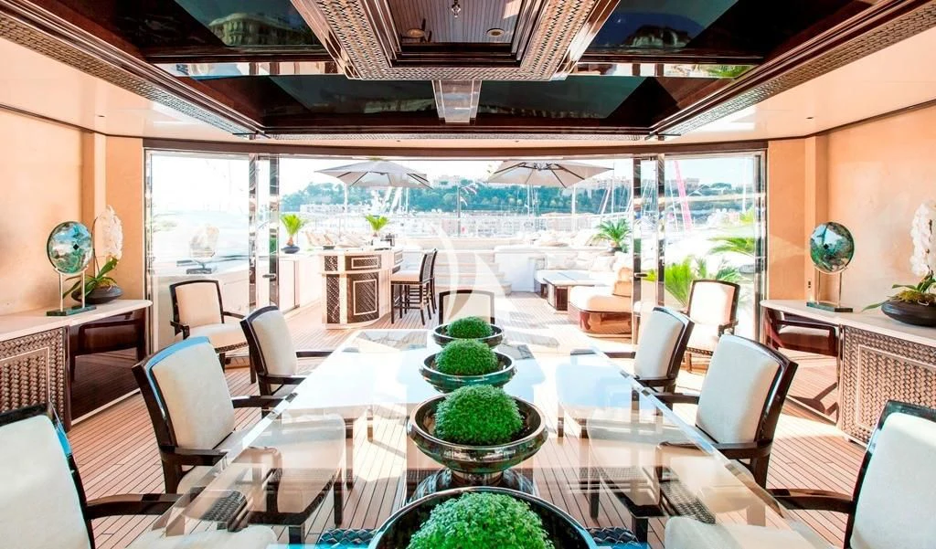 a large room with tables and chairs aboard ILLUSION V Yacht for Charter