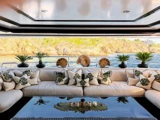 a table with a blue tablecloth and a white couch with plants on it aboard ILLUSION V Yacht for Charter