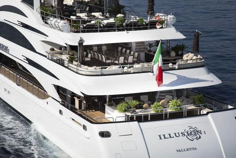 a large white ship with a flag on it aboard ILLUSION V Yacht for Charter