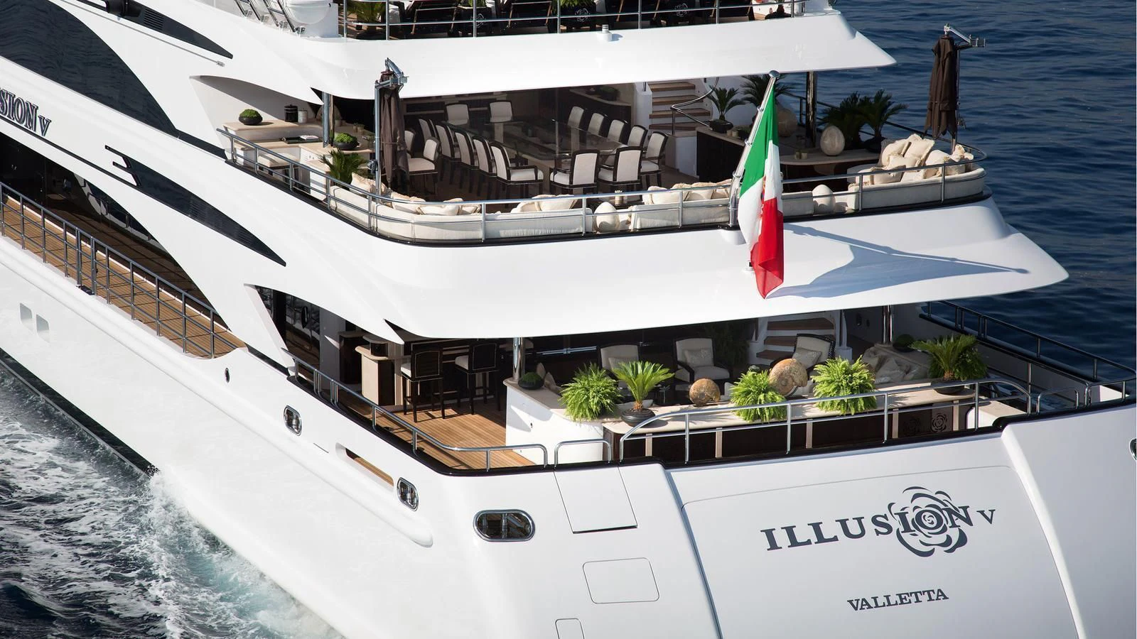 a white boat with a flag on it aboard ILLUSION V Yacht for Charter