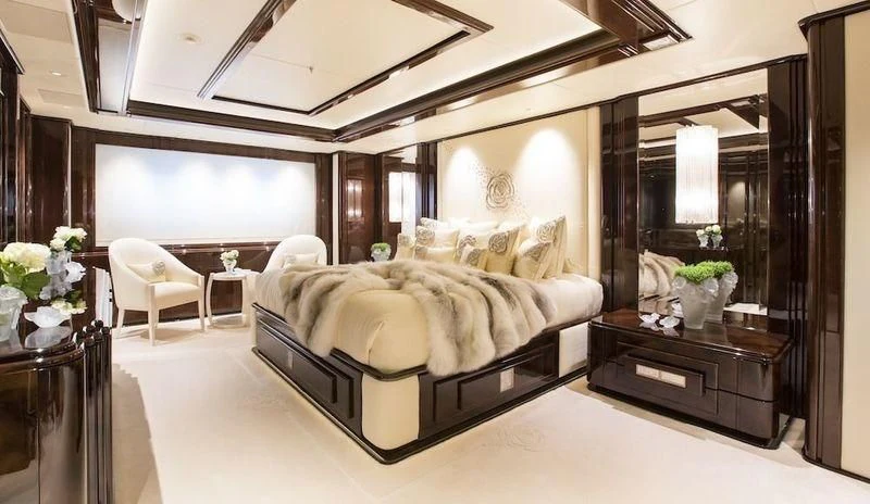 a large bedroom with a large mirror aboard ILLUSION V Yacht for Charter