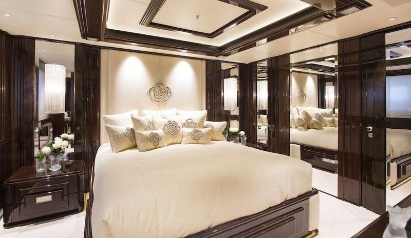 a bedroom with a large mirror aboard ILLUSION V Yacht for Charter