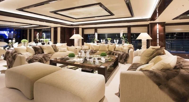 a living room with a large sofa and a table aboard ILLUSION V Yacht for Charter