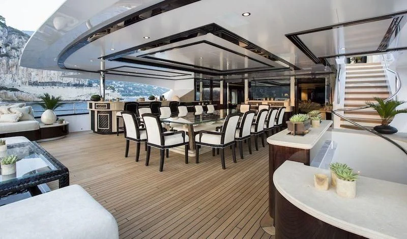 a room with a table chairs and a plant on the wall aboard ILLUSION V Yacht for Charter
