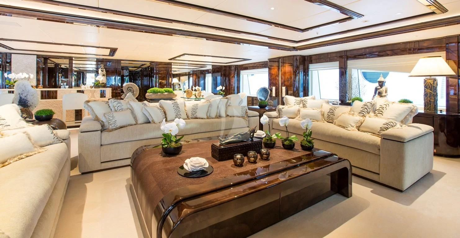 a living room with a large sofa and a coffee table aboard ILLUSION V Yacht for Charter
