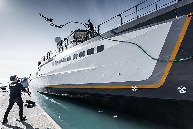 a man standing next to a large ship aboard GENE CHASER Yacht for Sale