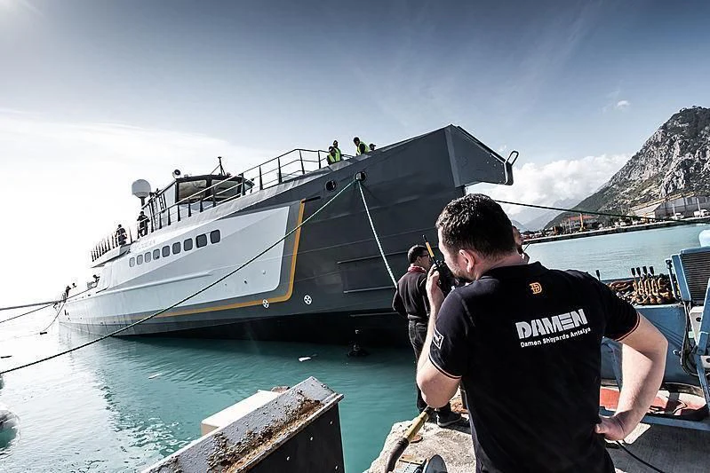 a man sitting on a rock by a boat in the water aboard GENE CHASER Yacht for Sale