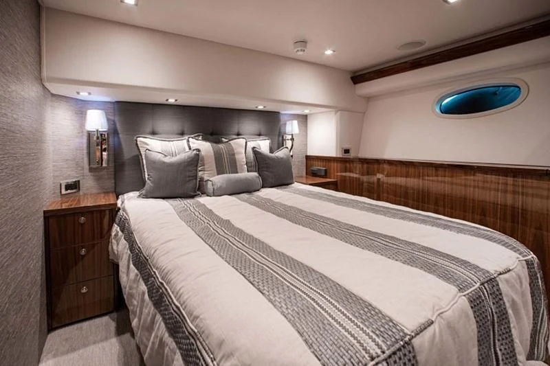 a bed with a white comforter aboard MANA Yacht for Sale