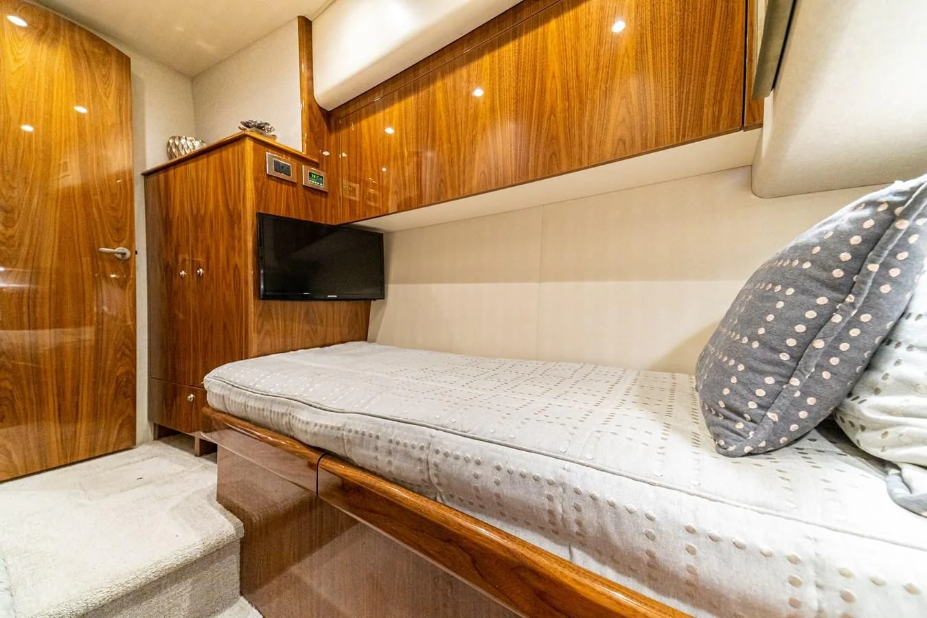 a bed with a television on the wall aboard MANA Yacht for Sale