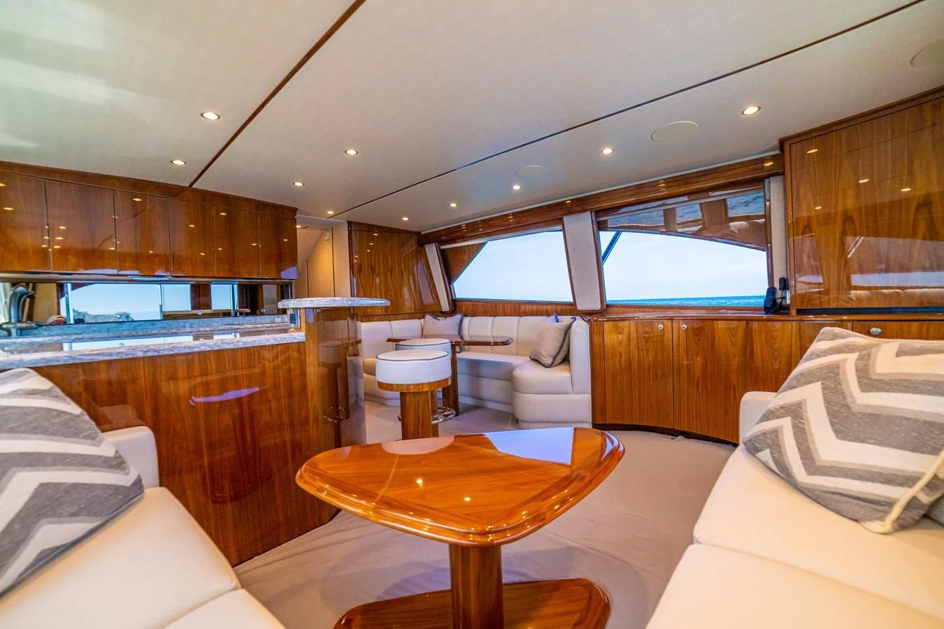 a living room with a table and couches aboard MANA Yacht for Sale