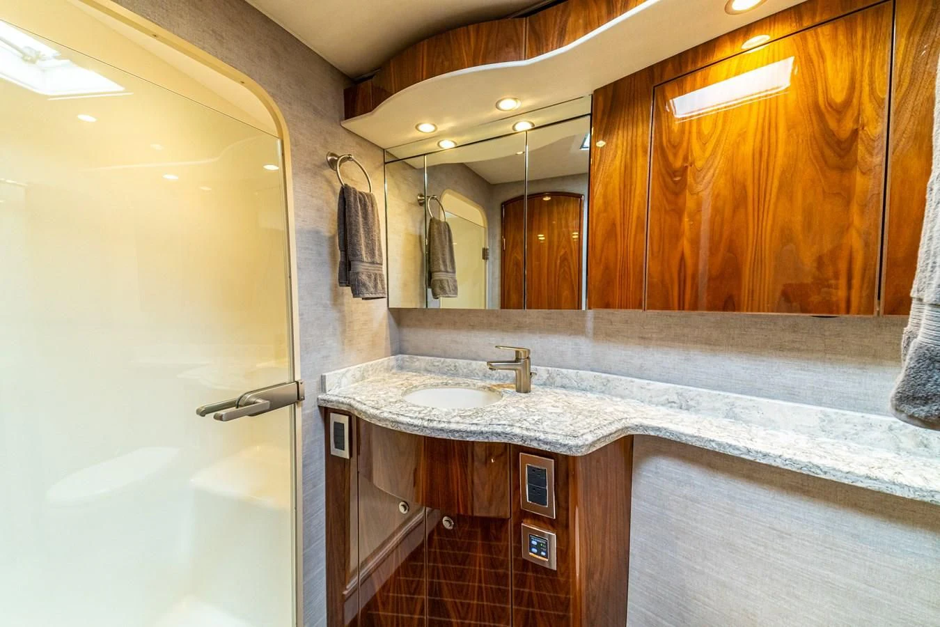 a bathroom with a countertop sink and wooden cabinets aboard MANA Yacht for Sale