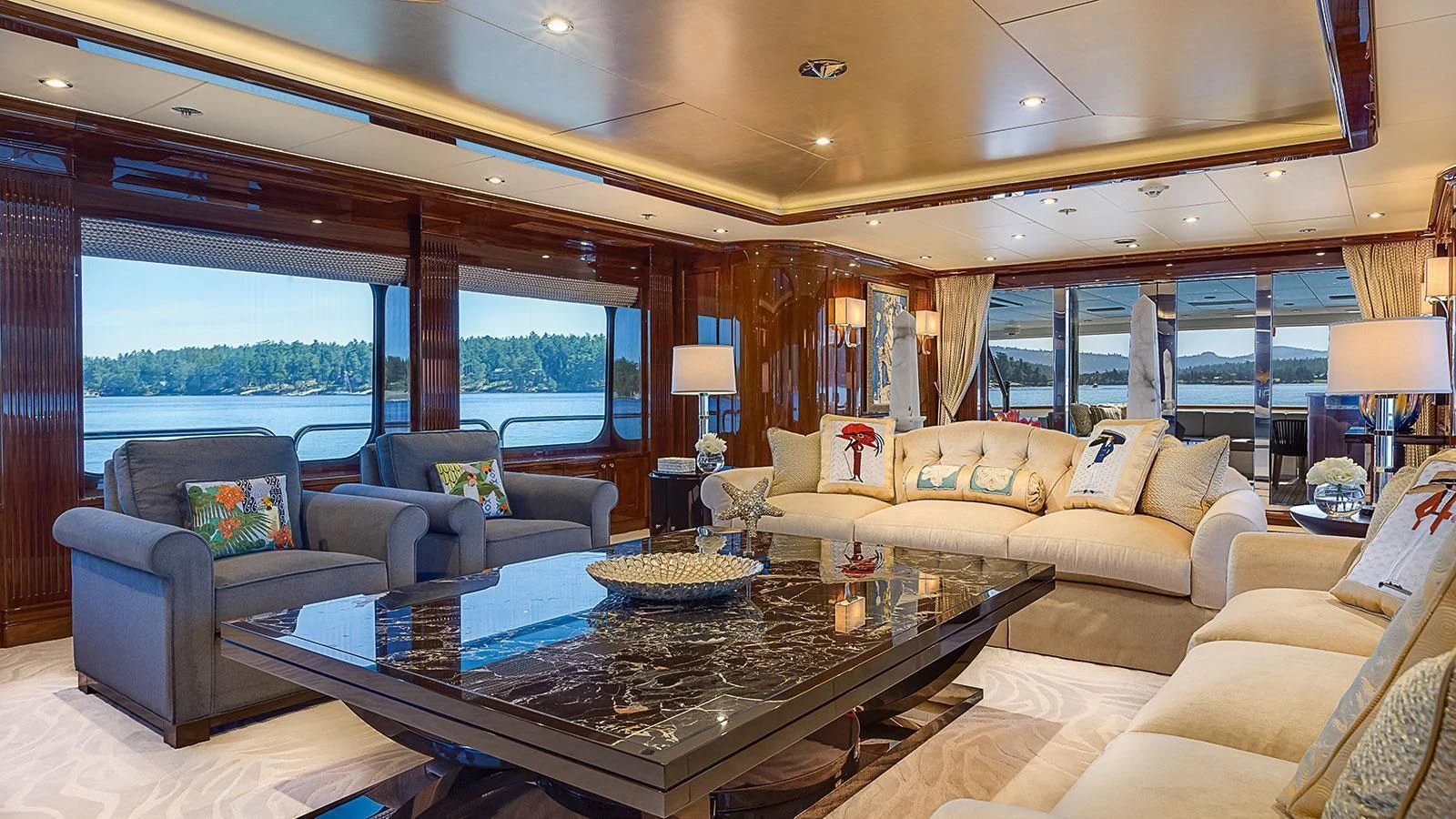 a living room with a large glass coffee table and a large window aboard D'NATALIN IV Yacht for Sale
