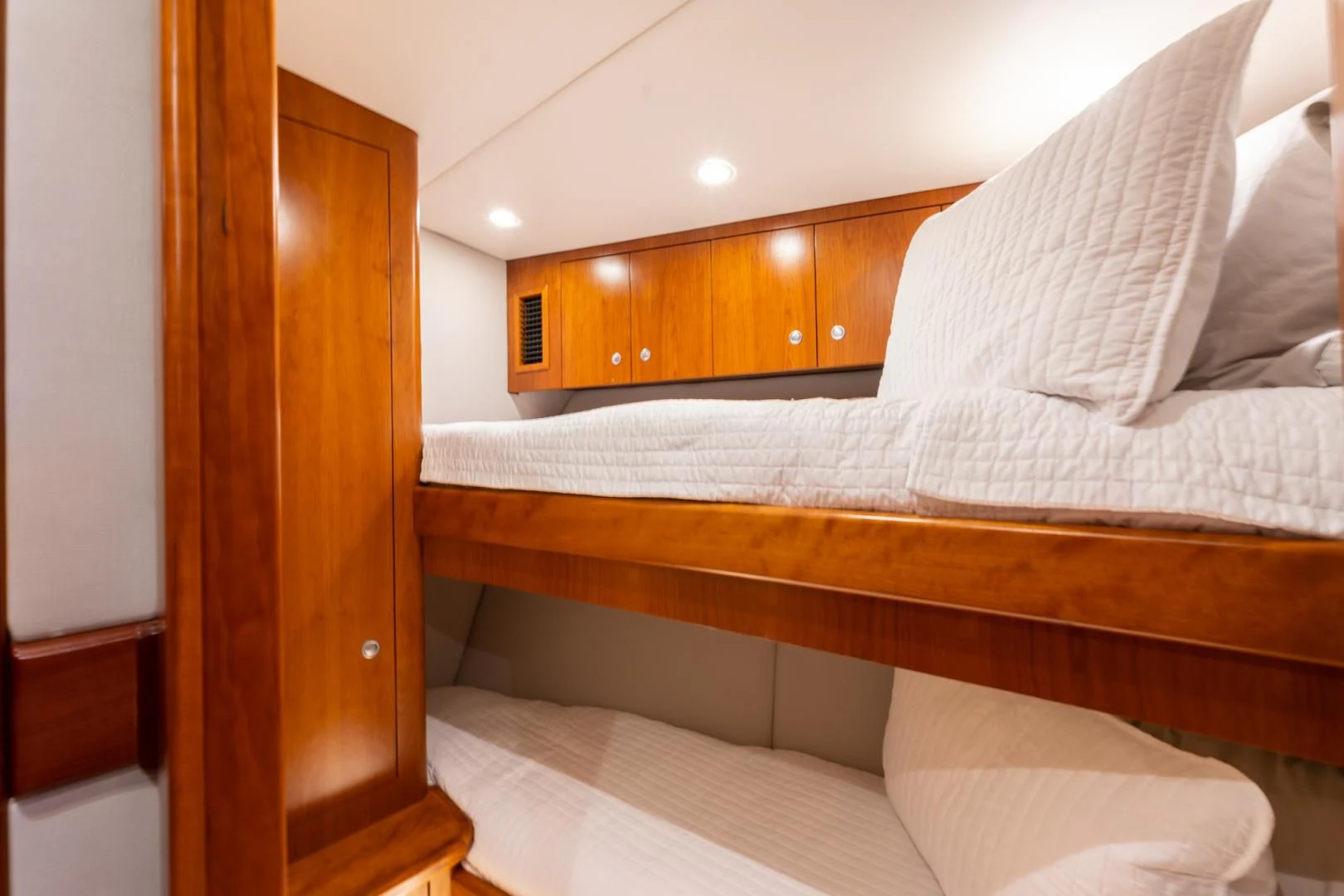 a room with a bed and a wood cabinet aboard LET  RIDE Yacht for Sale