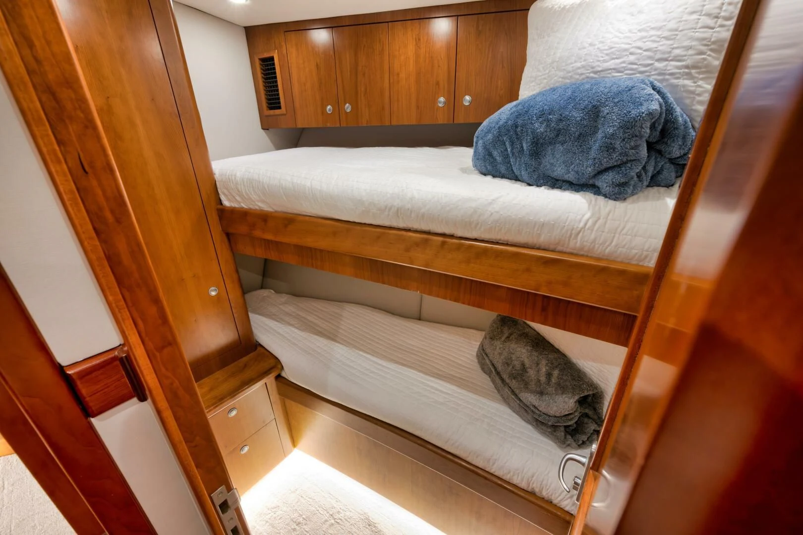 a bed with a blue pillow aboard LET  RIDE Yacht for Sale