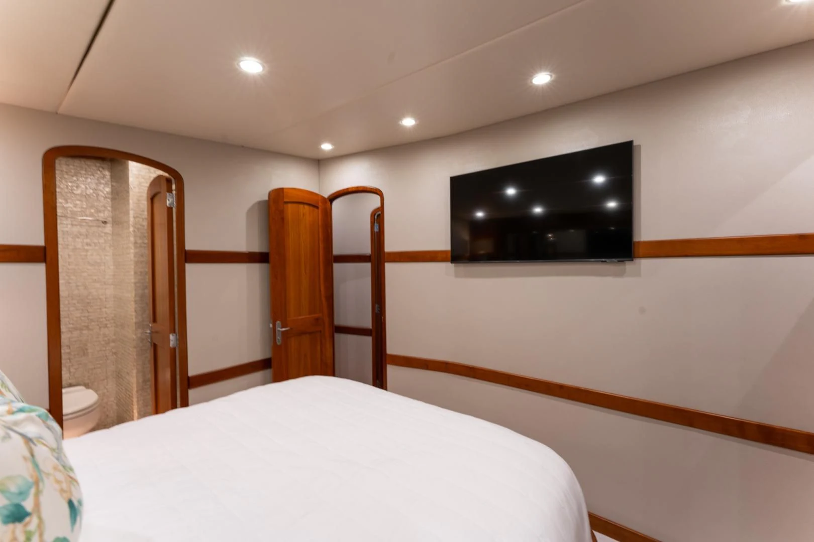 a bedroom with a tv on the wall aboard LET  RIDE Yacht for Sale