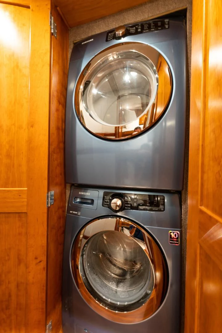 a washer and dryer in a wooden room aboard LET  RIDE Yacht for Sale