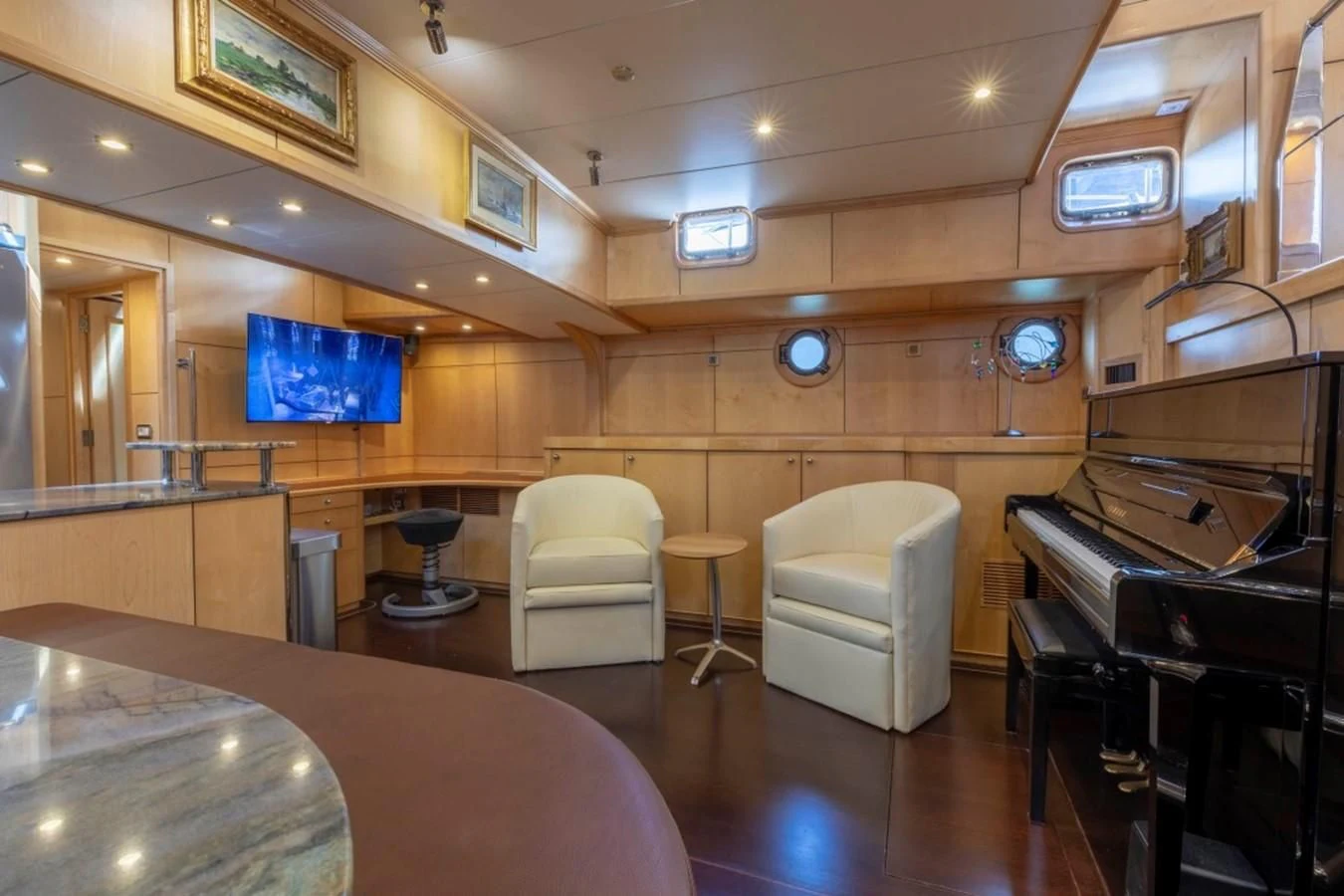 a room with a piano and a table and chairs aboard DE VROUWE CHRISTINA Yacht for Sale