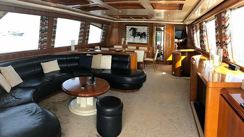a living room with a black couch and a coffee table aboard BARON B Yacht for Sale
