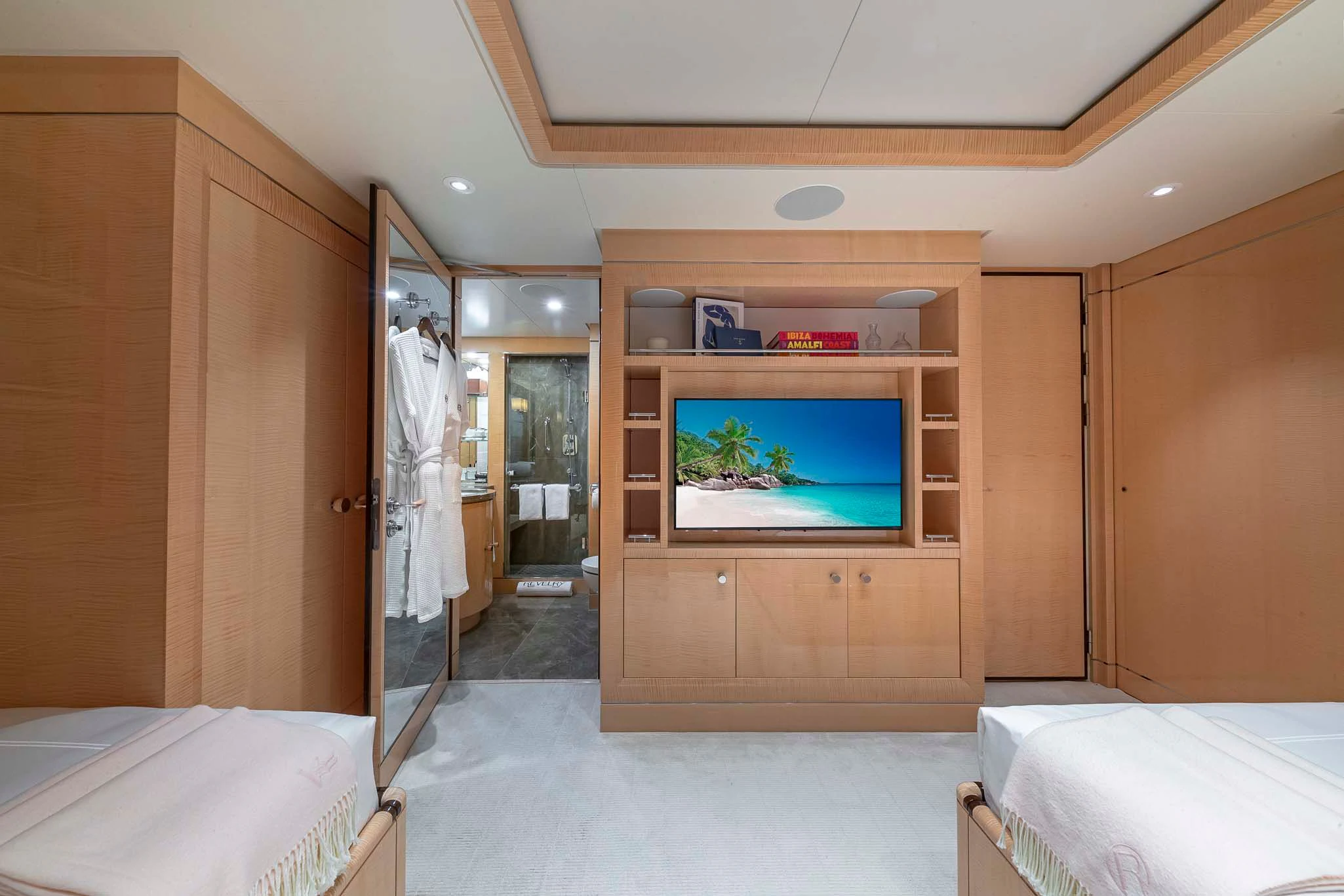 a room with a bed and a television aboard REVELRY Yacht for Sale
