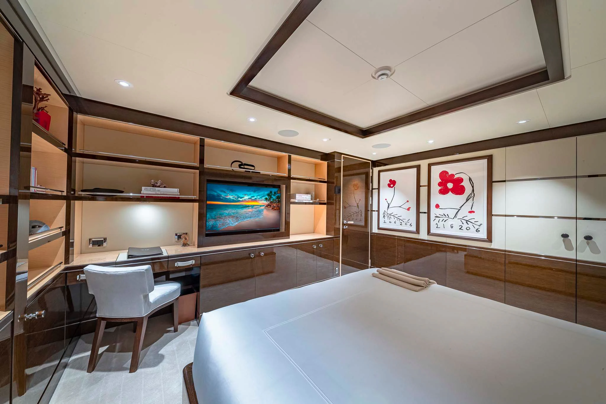 a room with a large tv and a table with chairs aboard REVELRY Yacht for Sale