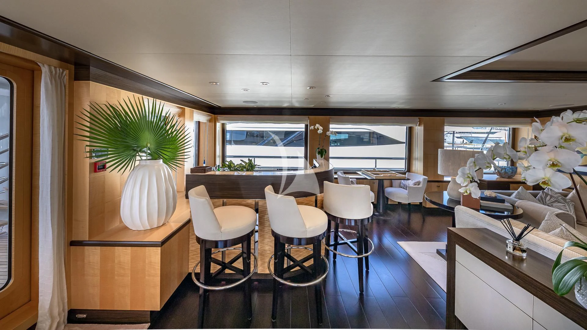 a room with tables chairs and plants aboard REVELRY Yacht for Sale