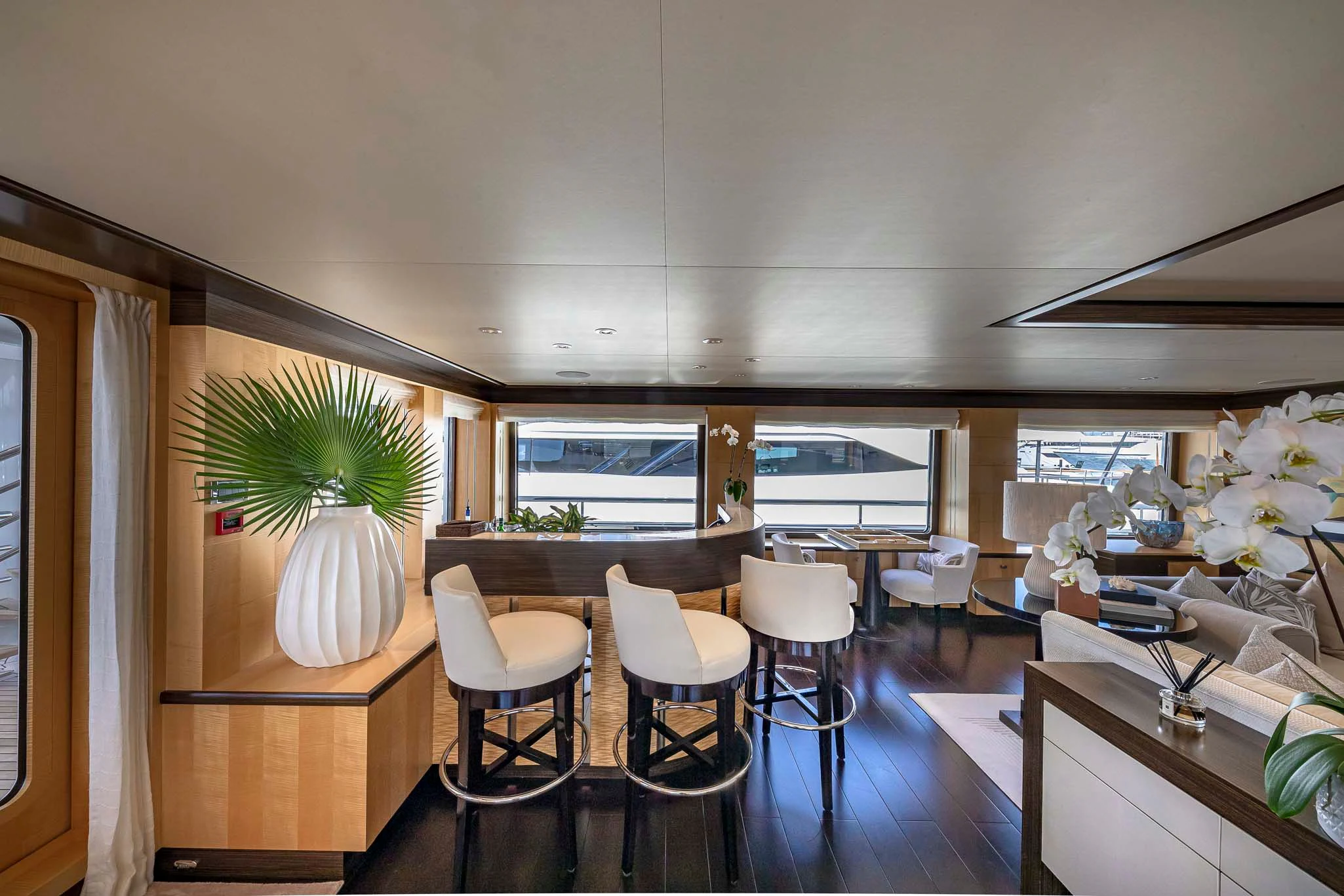 a room with a table chairs and a plant aboard REVELRY Yacht for Sale