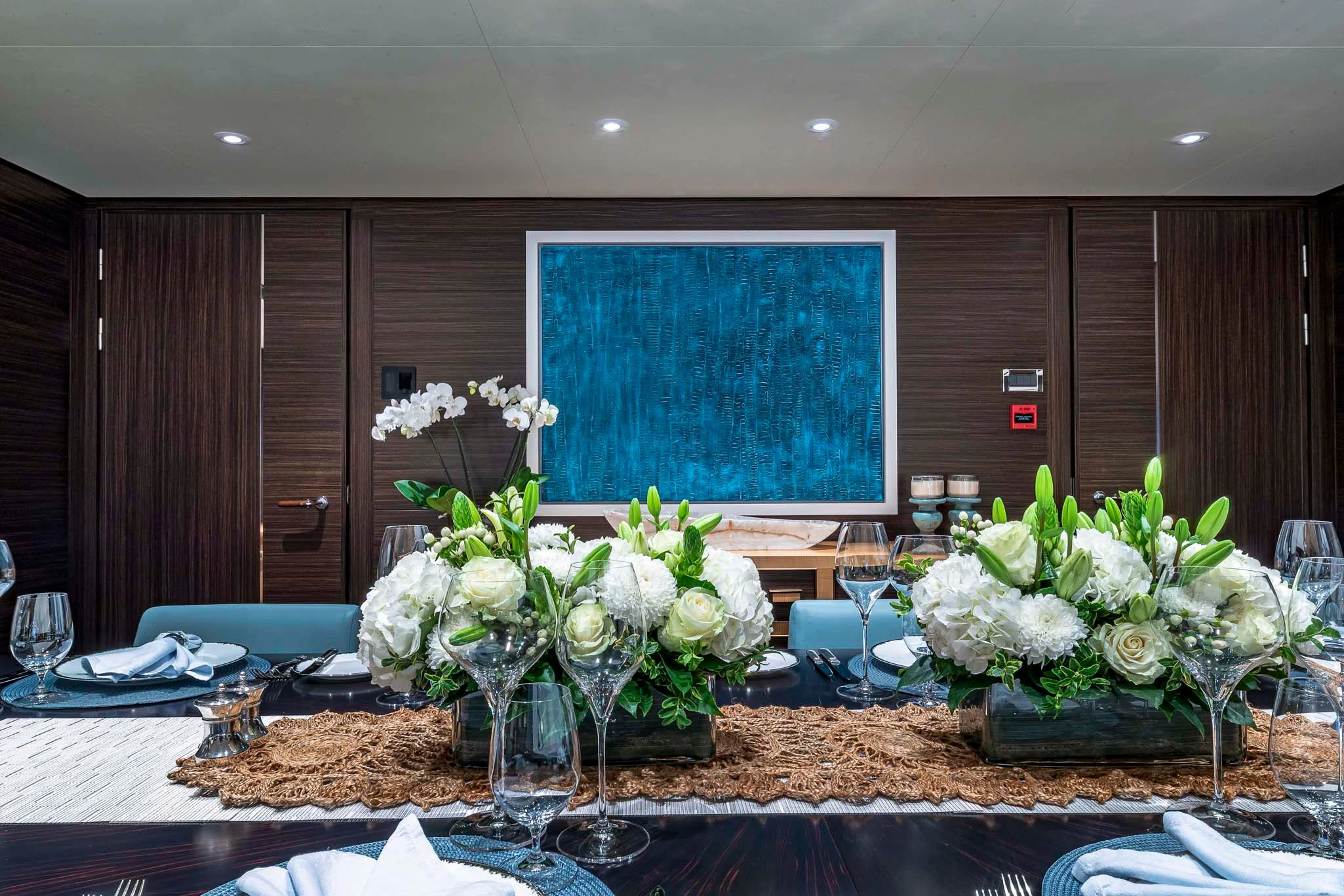 a table with vases of white flowers aboard REVELRY Yacht for Sale