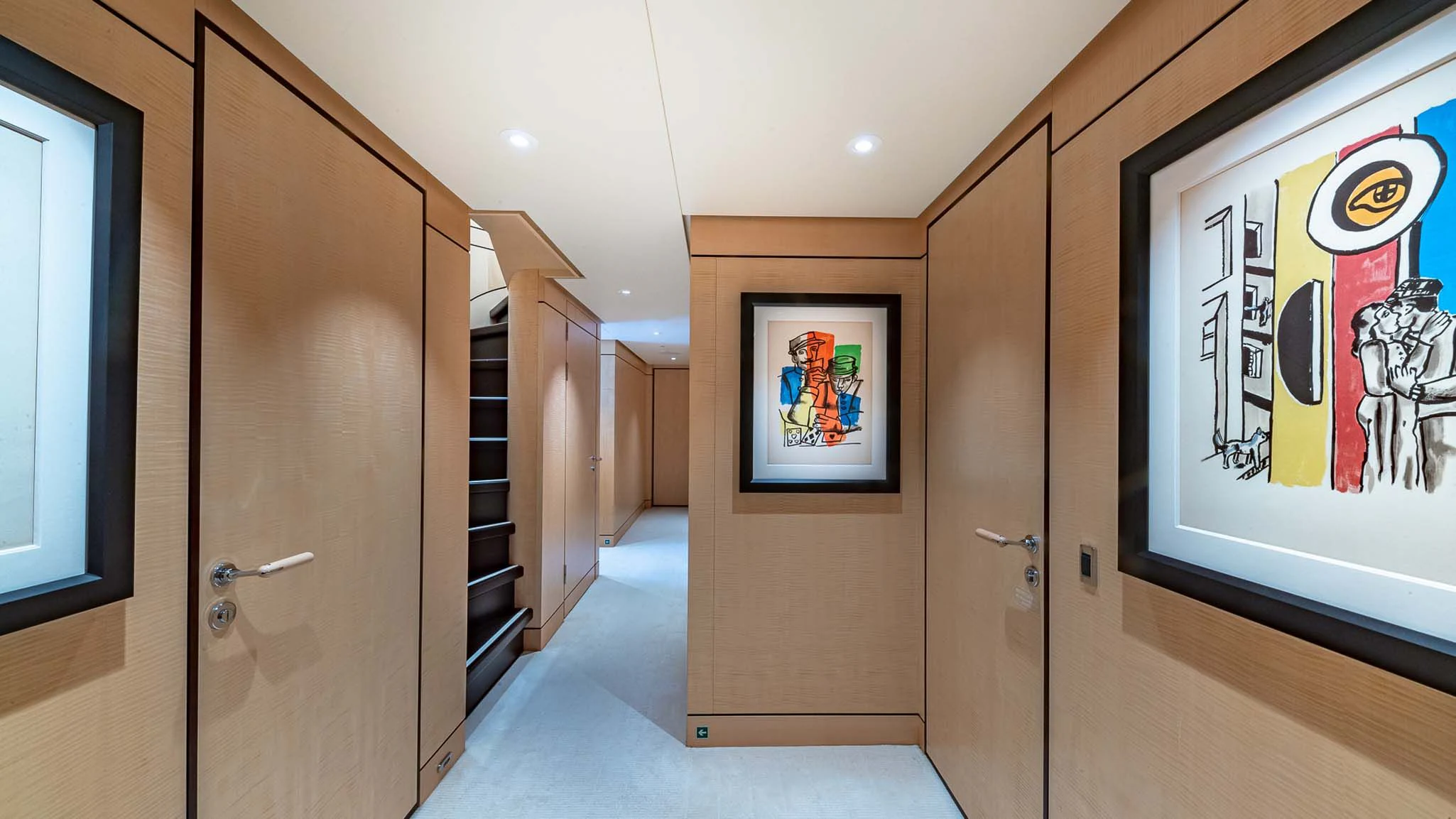 a hallway with doors and a painting on the wall aboard REVELRY Yacht for Sale