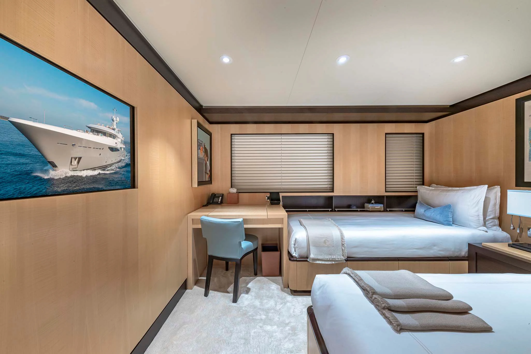 a room with a bed and a desk aboard REVELRY Yacht for Sale