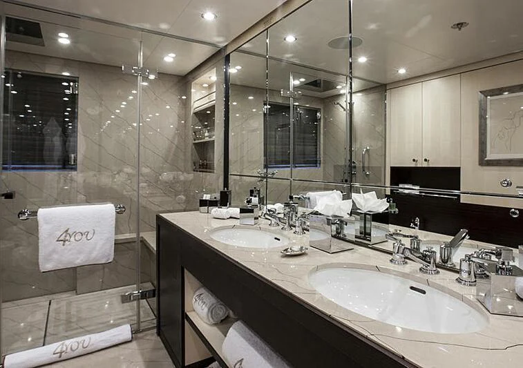 a bathroom with two sinks and a large mirror aboard REVELRY Yacht for Sale