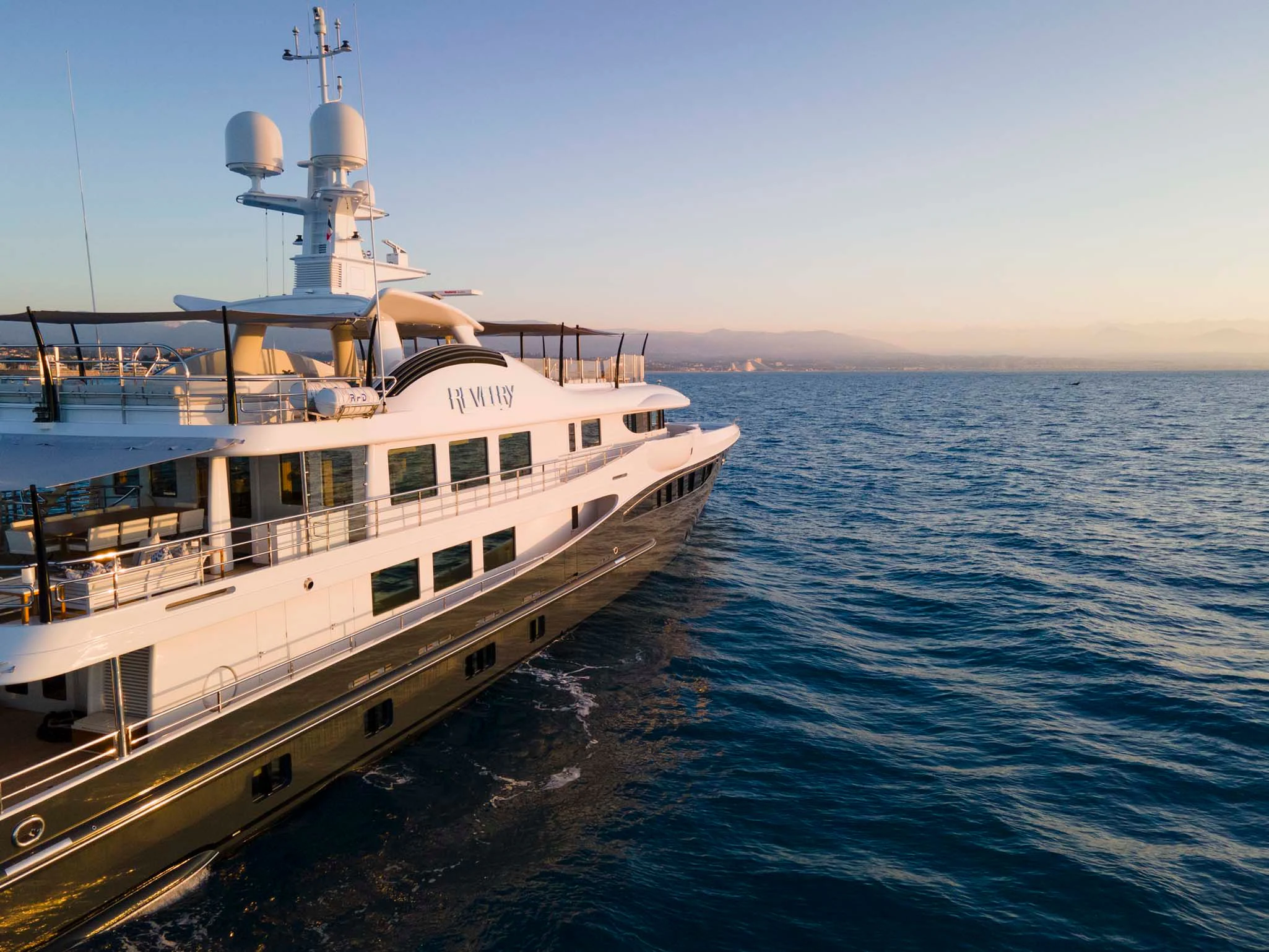 a large white boat on the water aboard REVELRY Yacht for Sale