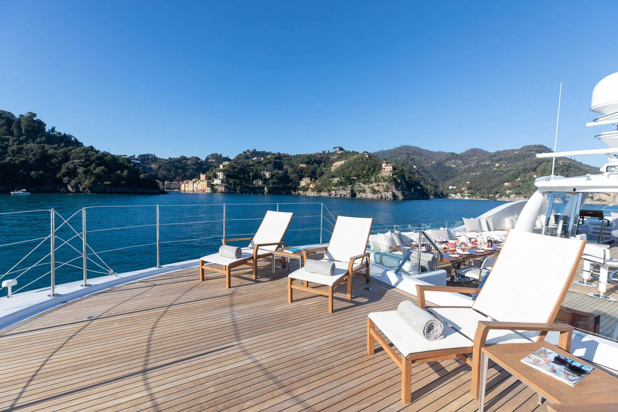 a deck with chairs and a laptop on it aboard REVELRY Yacht for Sale