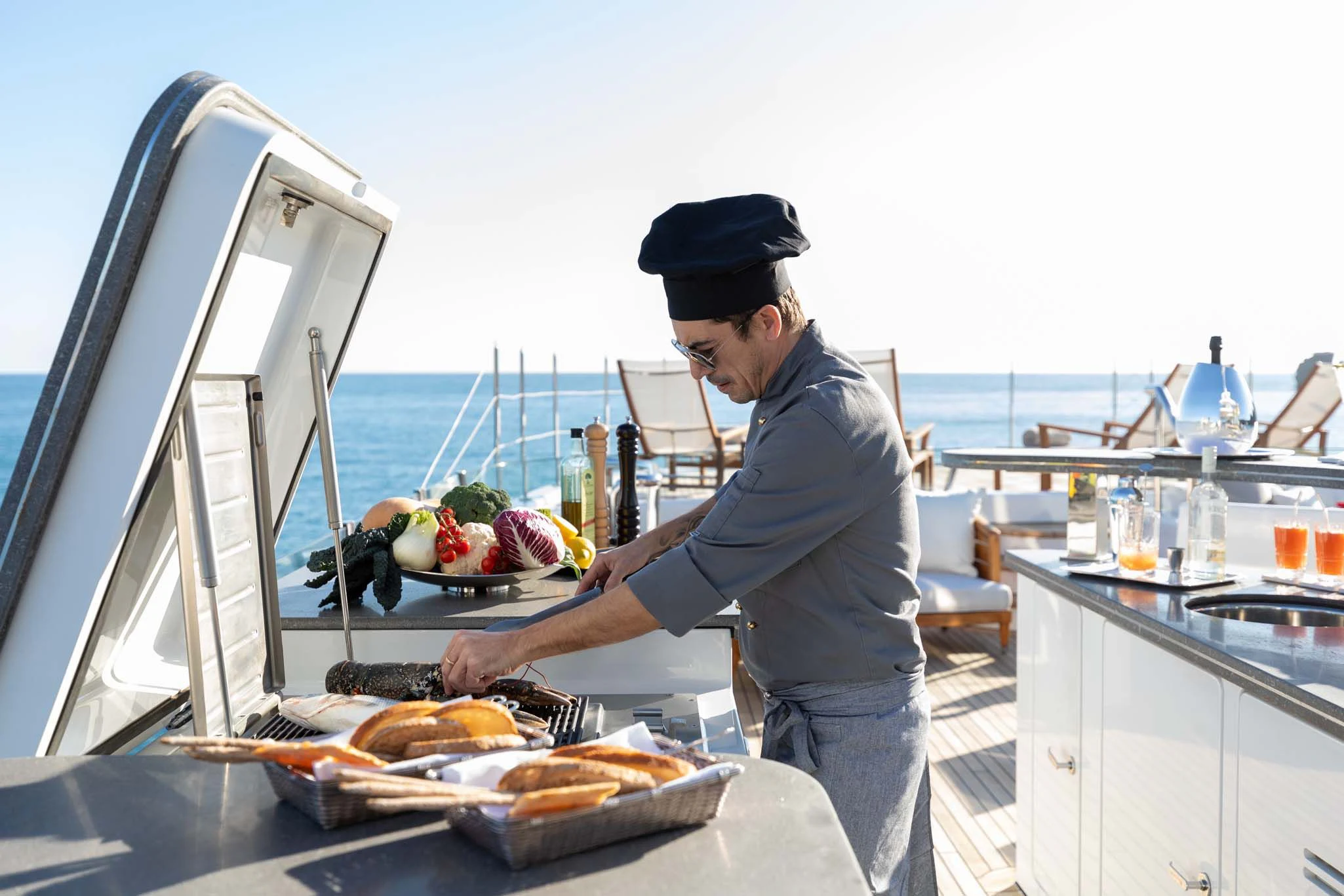 a man preparing food on a boat aboard REVELRY Yacht for Sale