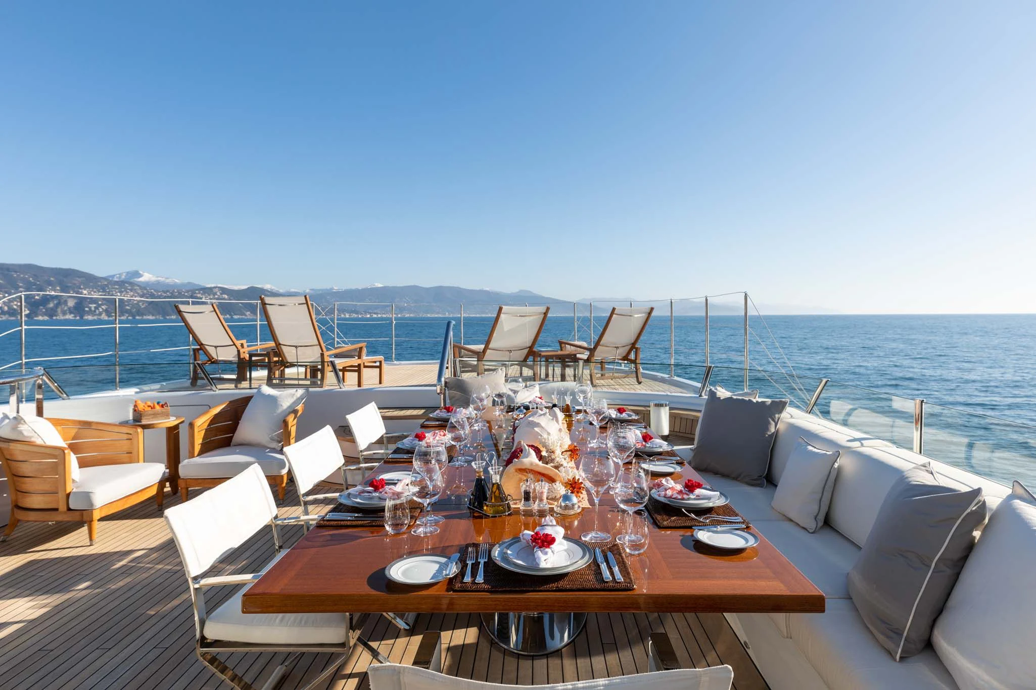 a table set for a meal on a deck overlooking the ocean aboard REVELRY Yacht for Sale