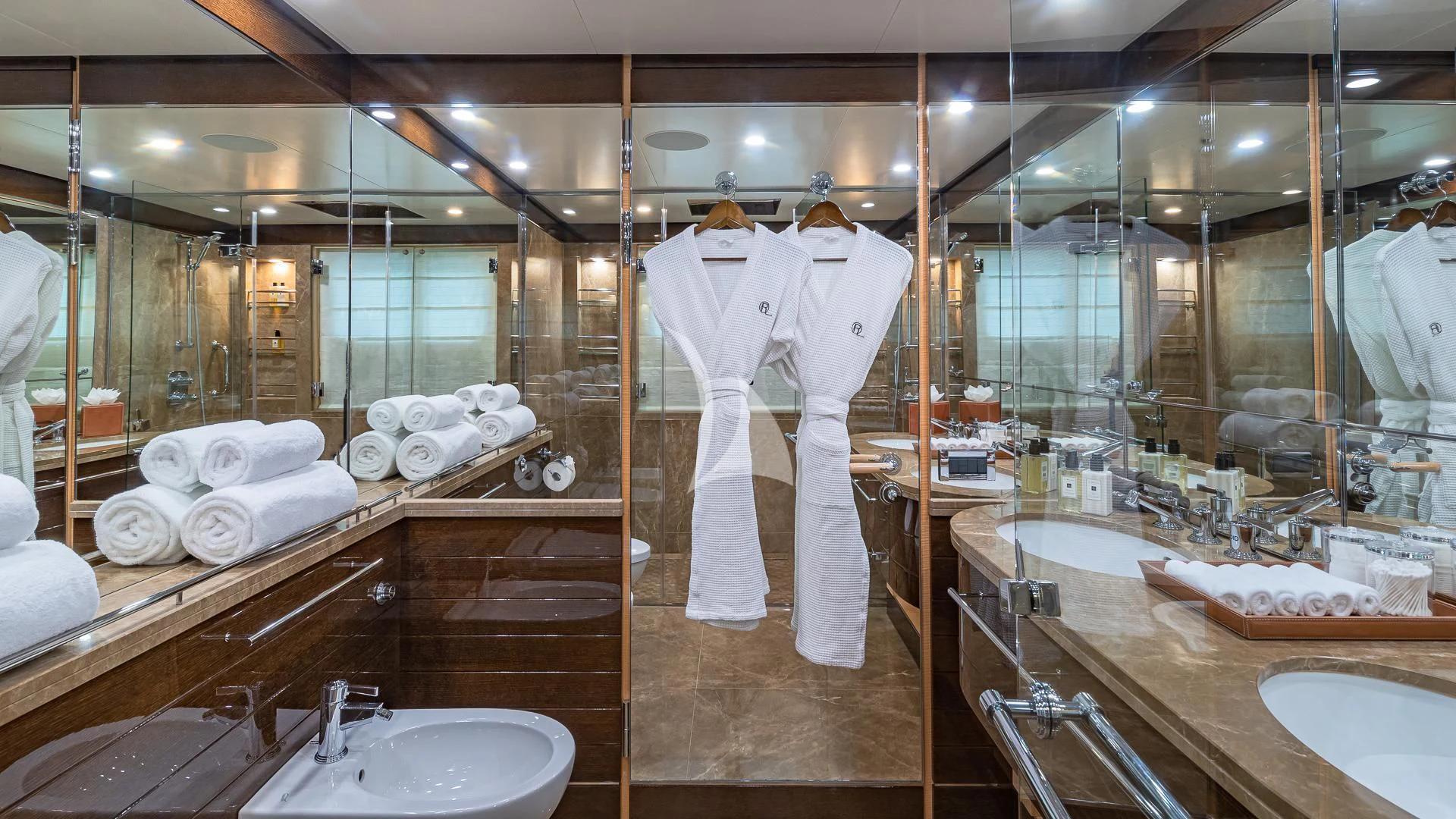 a large bathroom with a large display of towels and a robe aboard REVELRY Yacht for Sale