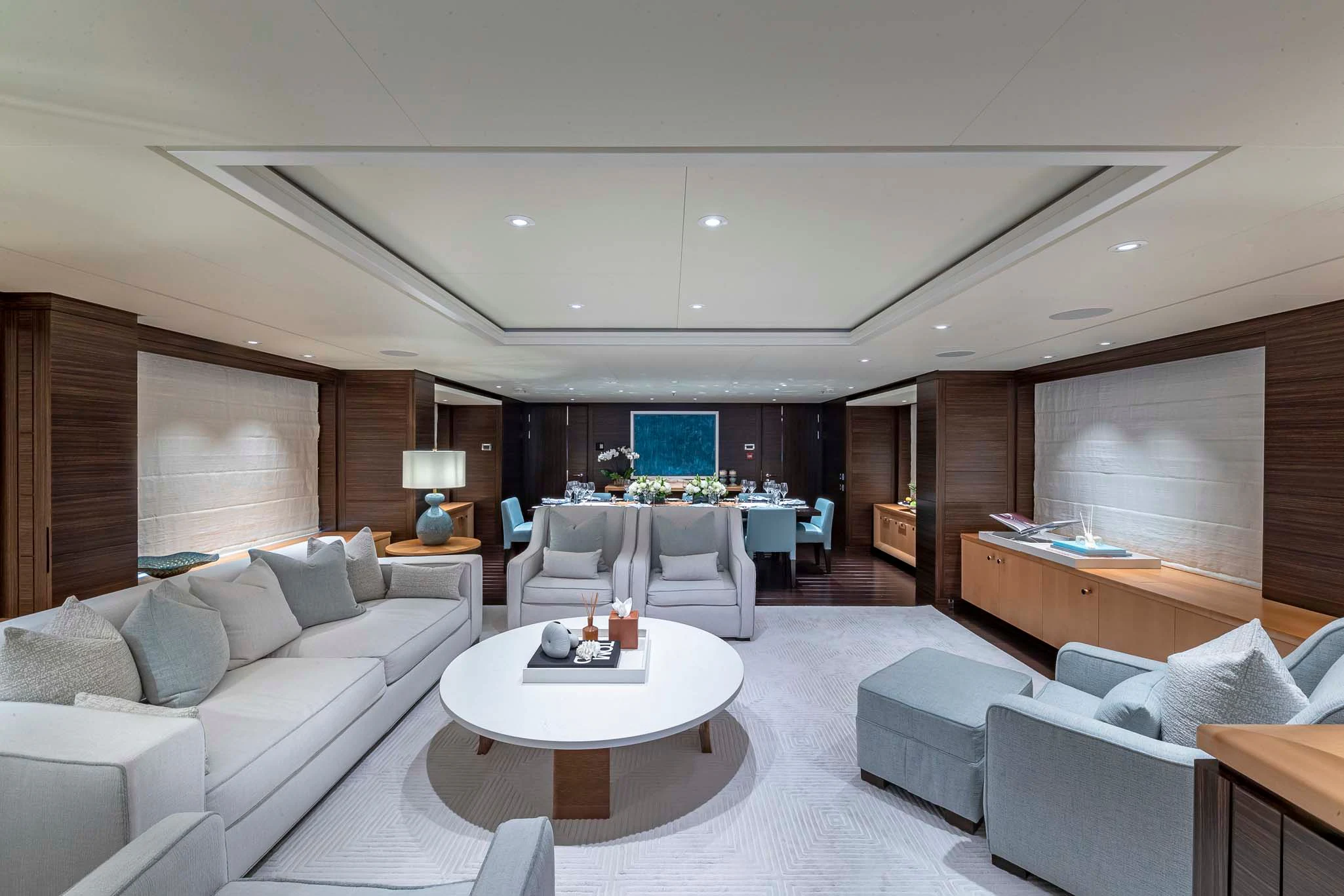 a living room with a large white sofa and a large white table aboard REVELRY Yacht for Sale