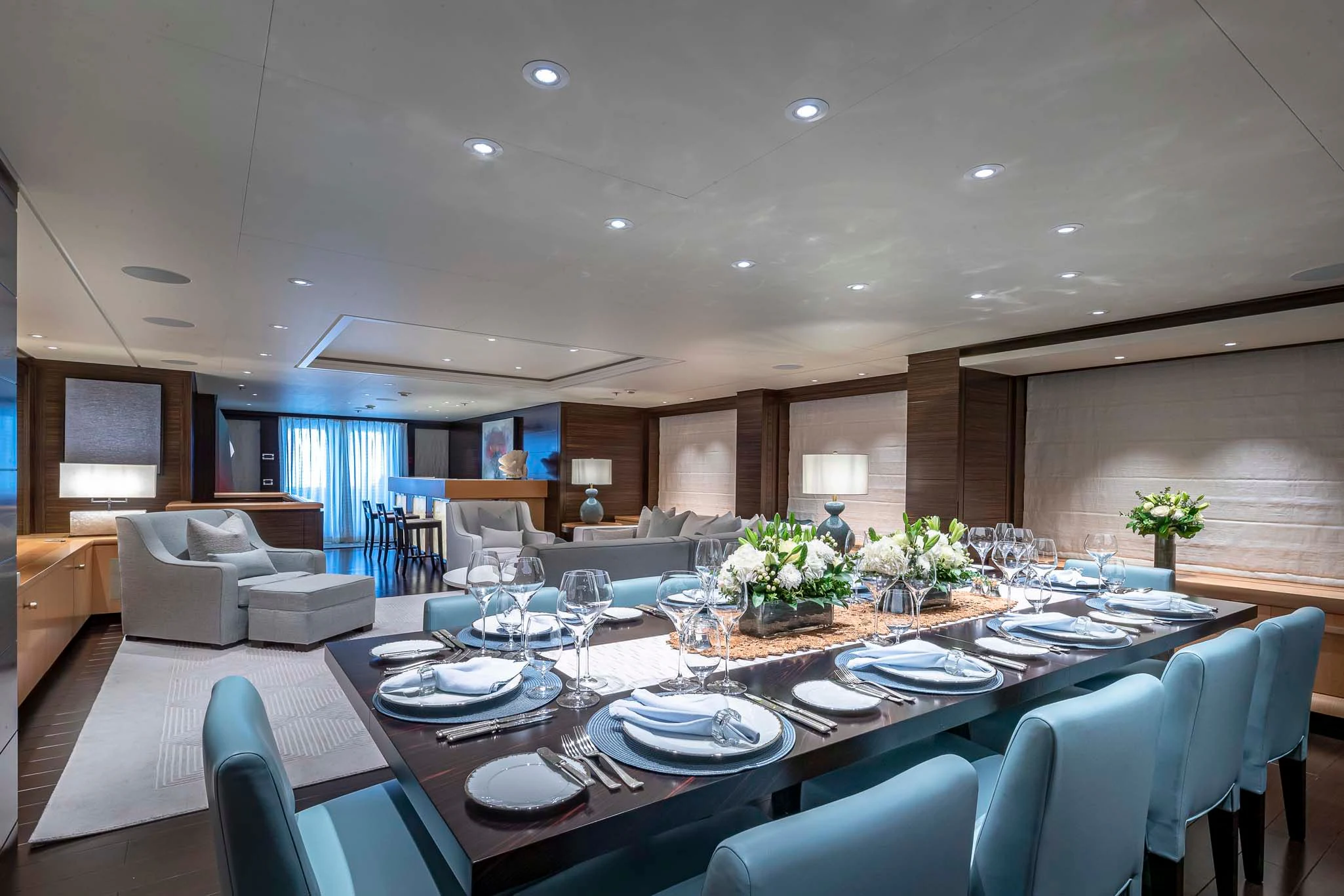 a large dining room with white chairs aboard REVELRY Yacht for Sale