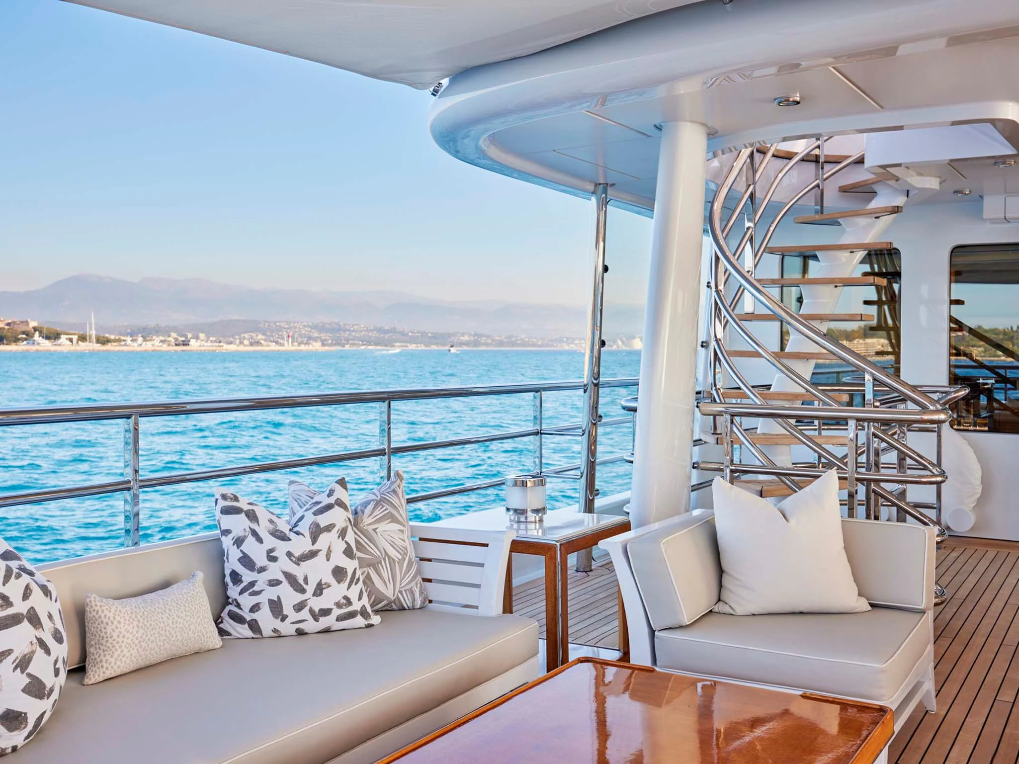 a balcony with a view of the ocean and mountains aboard REVELRY Yacht for Sale