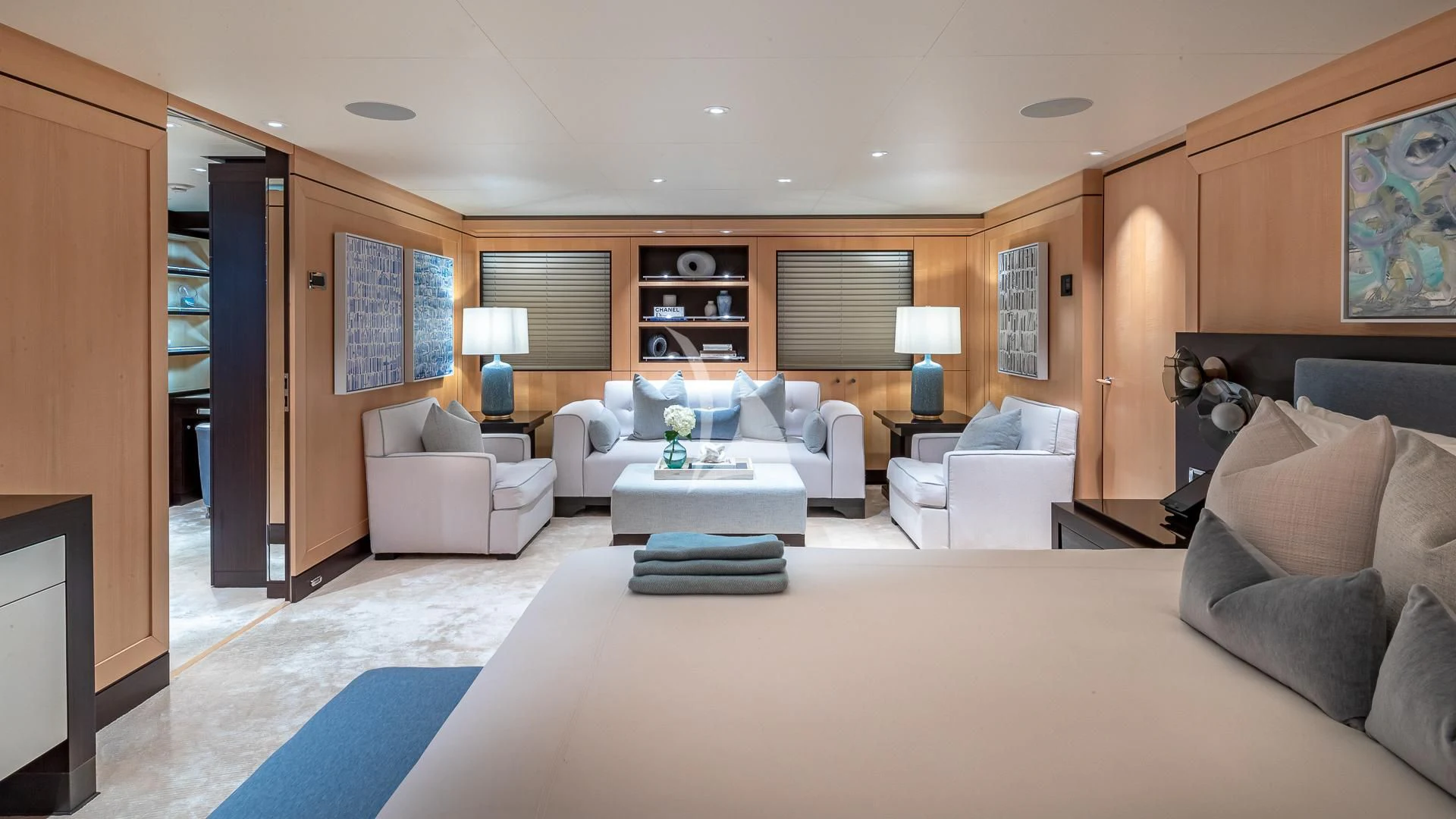 a living room with a large white bed and a blue rug aboard REVELRY Yacht for Sale