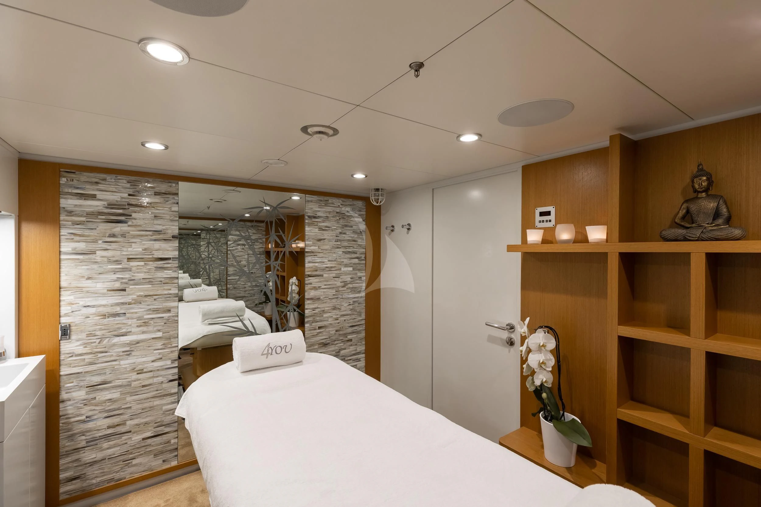 a room with a bed and a shelf with objects on it aboard REVELRY Yacht for Sale