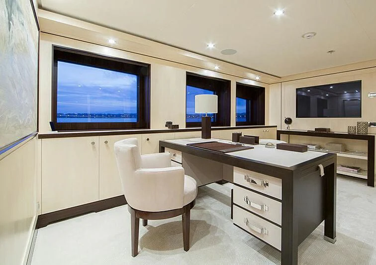 a room with a desk and a tv on the wall aboard REVELRY Yacht for Sale