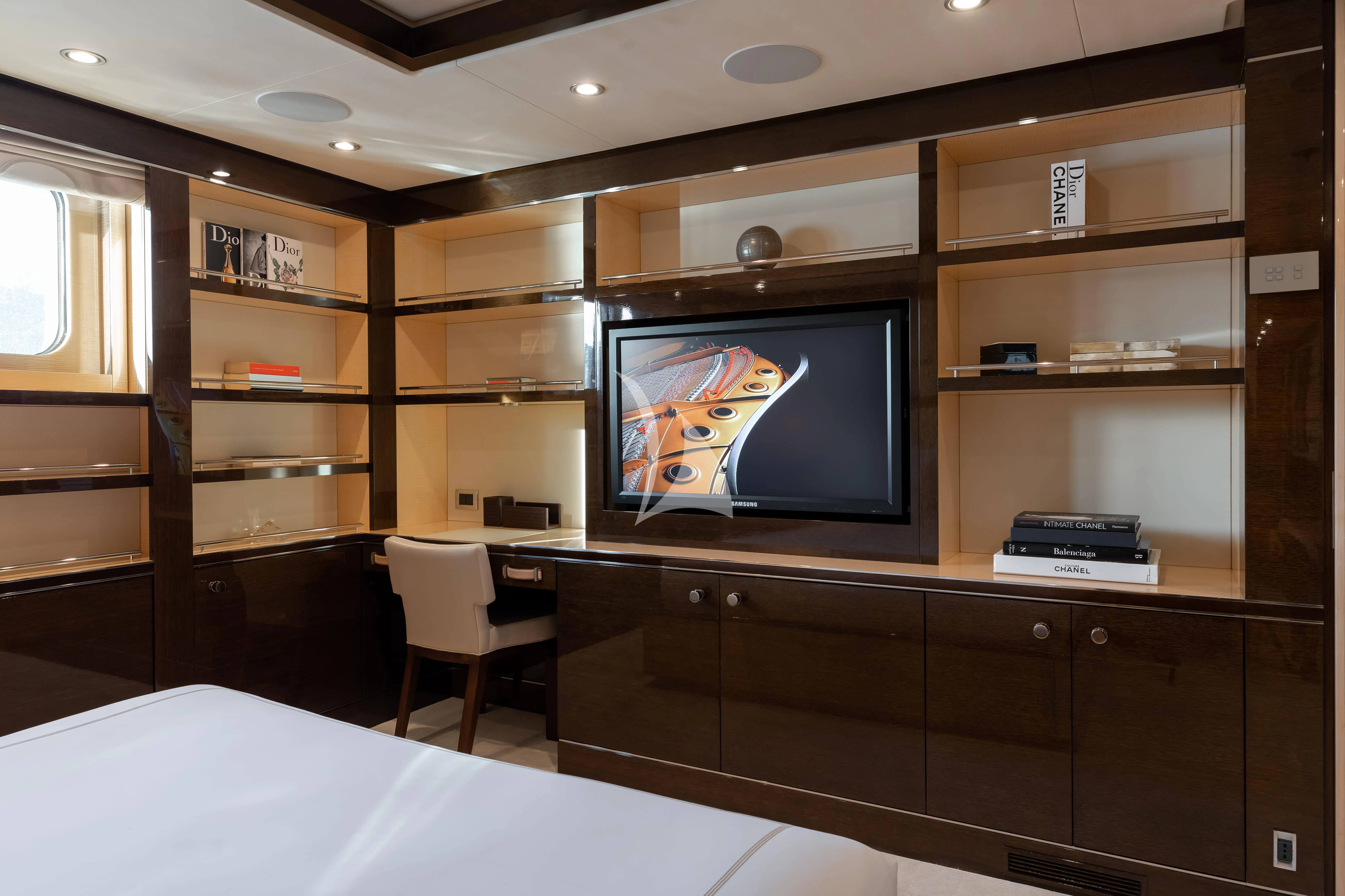 a room with a tv and a bookcase aboard REVELRY Yacht for Sale