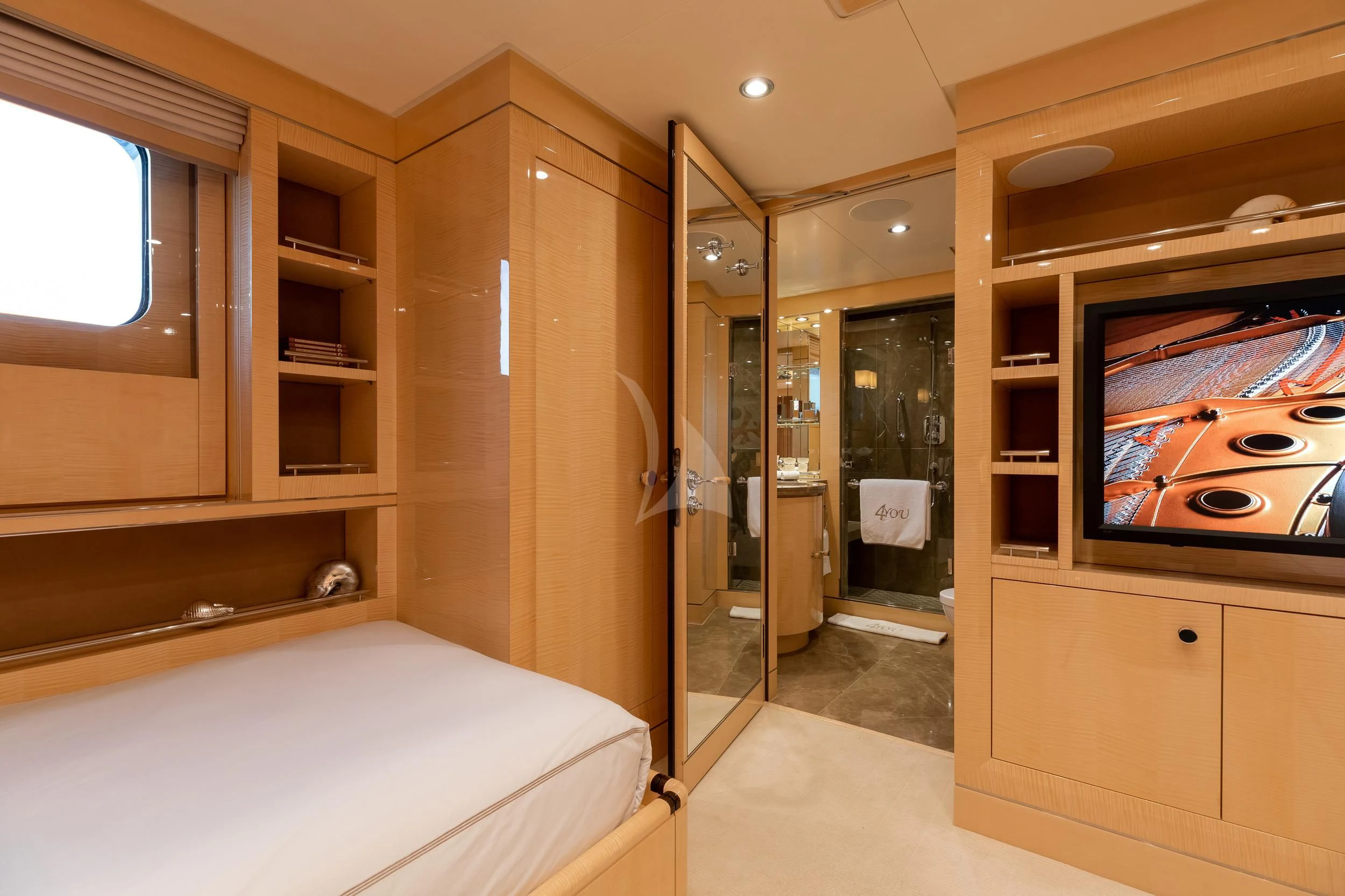 a bedroom with a bed and a television aboard REVELRY Yacht for Sale