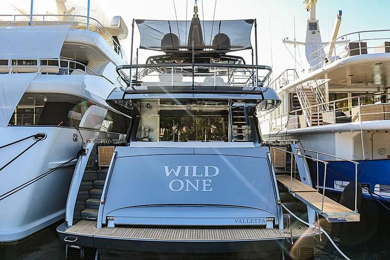 a large white boat with a blue stripe aboard YOYITA II Yacht for Sale