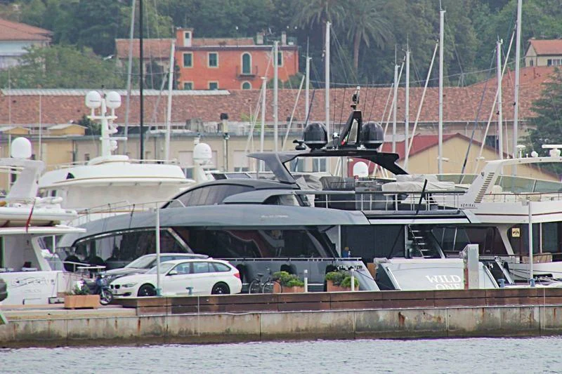 a white car parked next to a boat on a dock aboard YOYITA II Yacht for Sale