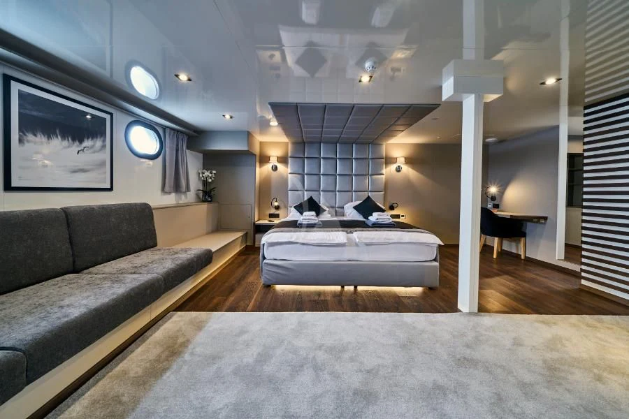 a large living room with a large bed and a large window aboard RARA AVIS Yacht for Charter