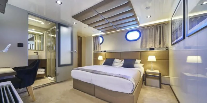 a room with a bed and a chair aboard RARA AVIS Yacht for Charter
